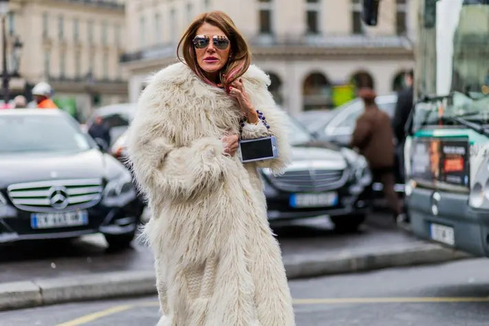 Stylish women wearing eco-friendly faux fur coats in winter